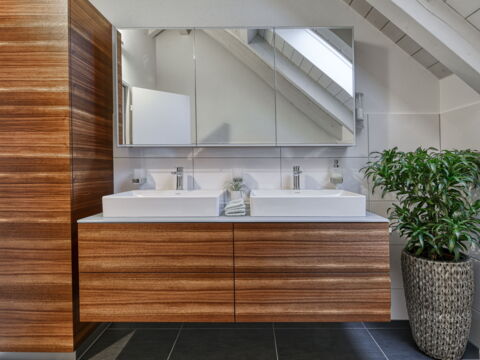 Doppelwaschbecken mit Holzverkleidung und LED-Spiegel, Badezimmer-Umbau realisiert durch DIE SCHREINER