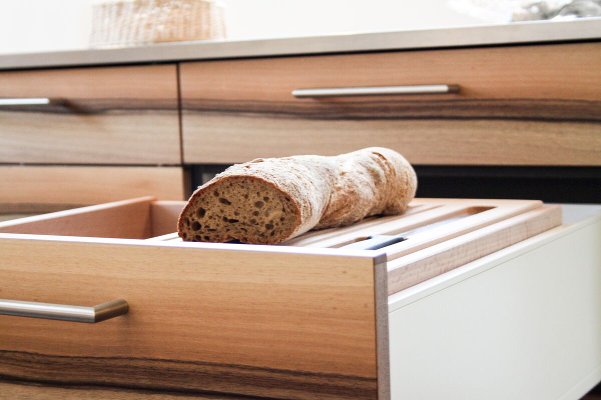 Moderne offene Küche in grün mit Holzdetails, Küchenumbau realisiert durch DIE SCHREINER