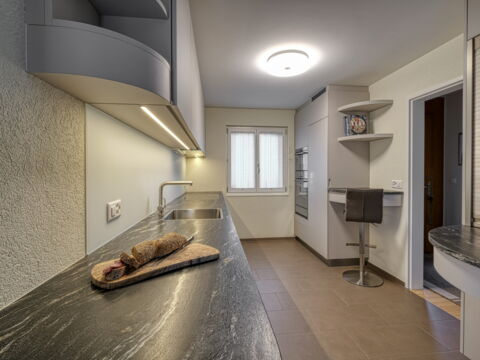Moderne Küche in grau mit Glasrückwand, Küchenumbau realisiert durch DIE SCHREINER