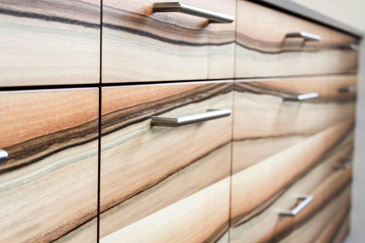 Moderne offene Küche in grün mit Holzdetails, Küchenumbau realisiert durch DIE SCHREINER
