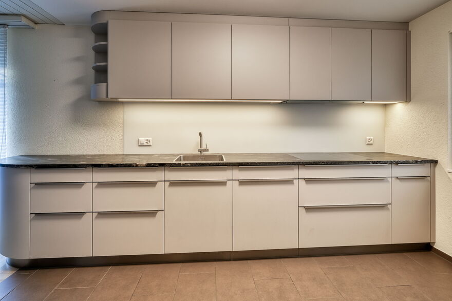 Moderne Küche in grau mit Glasrückwand, Küchenumbau realisiert durch DIE SCHREINER